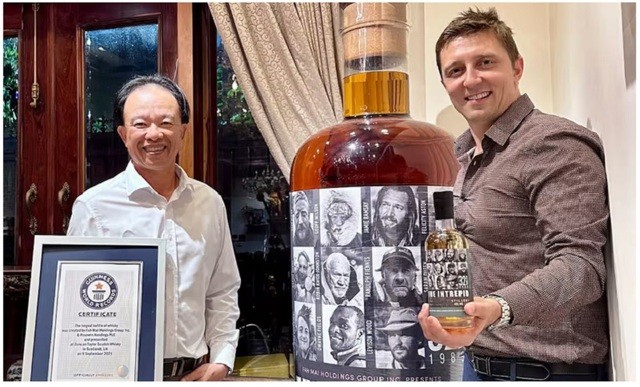 Ông Việt (trái) với chai rượu Intrepid và ông Daniel Monk, người tổ chức cuộc đấu giá 