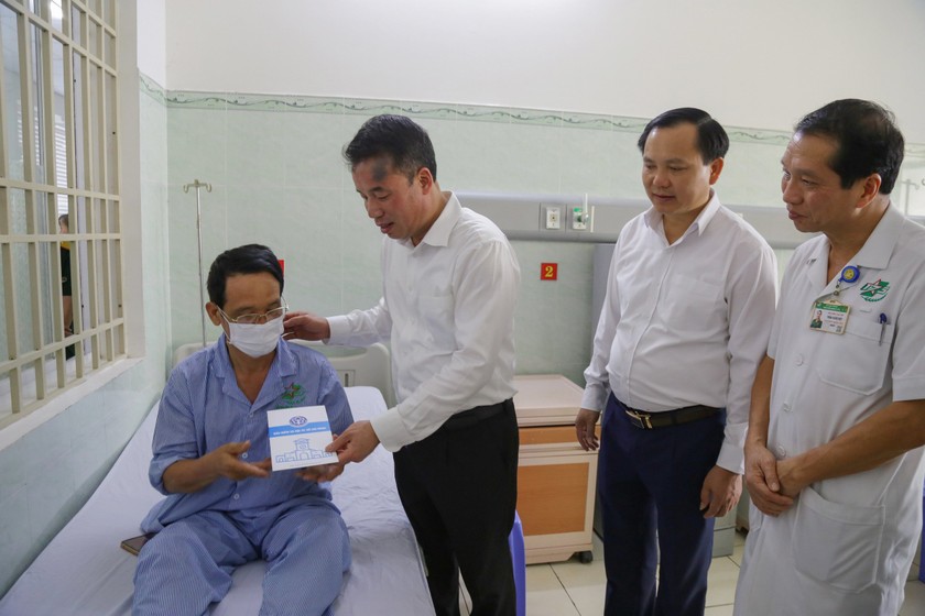 Tổng Giám đốc BHXH Việt Nam tặng sổ BHXH, thẻ BHYT và quà cho bệnh nhân nghèo. 