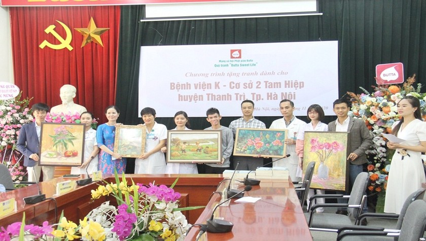 Họa sĩ Kim Đức (thứ ba từ trái sang) trao tặng bộ tranh cho Bệnh viện K cơ sở 2