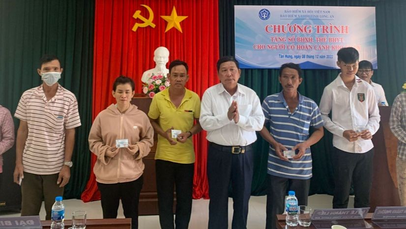 Ông Lê Thành Liếp - Phó Giám đốc BHXH tỉnh Long An trao thẻ BHYT cho người dân có hoàn cảnh khó khăn ở huyện Vĩnh Hưng
