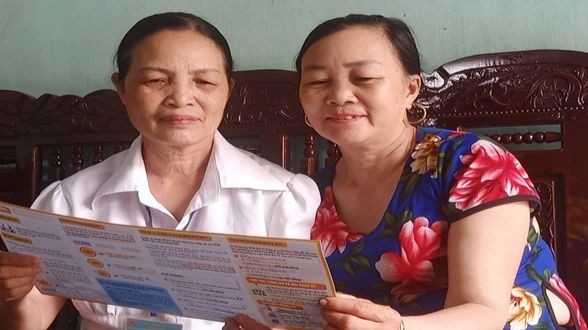 Bà Nguyễn Thị Thu Cống (bên trái) tuyên truyền chính sách BHXH tự nguyện, BHYT hộ gia đình.