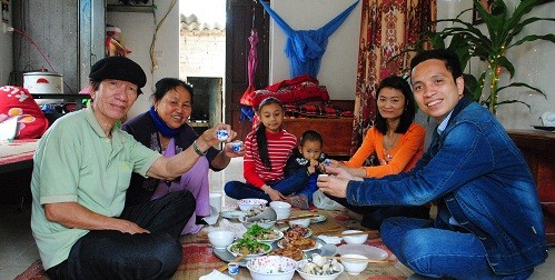 Tác giả (ngoài cùng, bên phải) cùng dự một bữa cơm với một gia đình ở làng phong.
