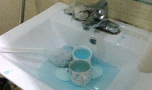 Nhân viên dung cọ toilet và nước rửa nhà vệ sinh để làm sạch cốc chén. Ảnh: Weibo.