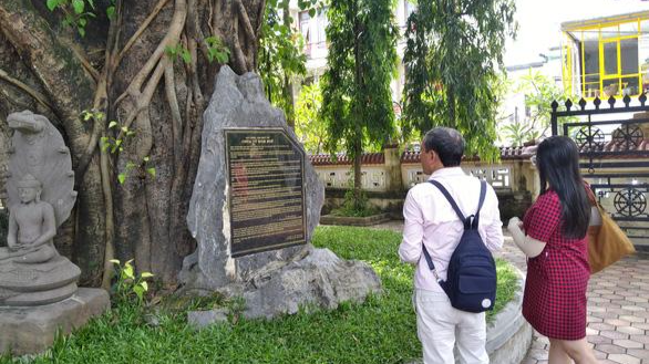 Du khách tham quan chùa Từ Đàm đang đọc tấm bia đá khắc sai tên vua Thiệu Trị - Ảnh: L.GIANG