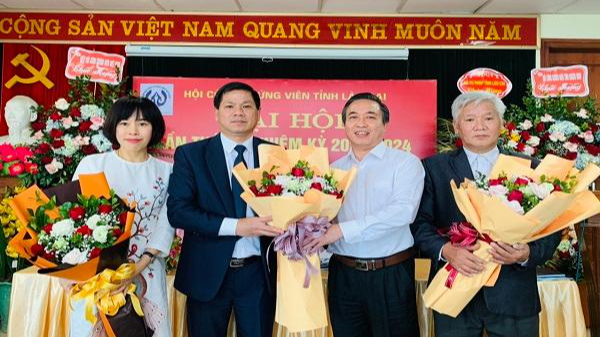 Ông Lê Ngọc Quỳnh, Giám đốc Sở Tư pháp Lào Cai (áo vest đứng giữa) tặng hoa chúc mừng Ban chấp hành Hội công chứng viên tỉnh Lào Cai khóa II 