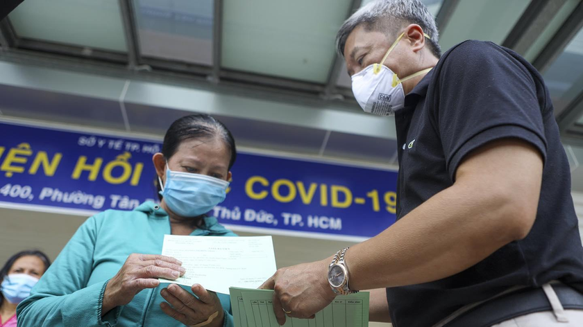 Một bệnh nhân COVID-19 được Thứ trưởng Bộ Y tế - ông Nguyễn Trường Sơn trao giấy ra viện. Ảnh: BV Chợ Rẫy