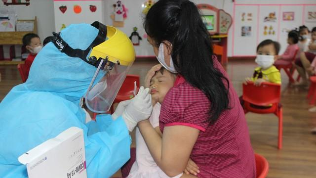 Nhân viên y tế lấy mẫu xét nghiệm cho học sinh trường Mầm non Sao Mai, TP Bắc Ninh. Ảnh: Việt Hoa