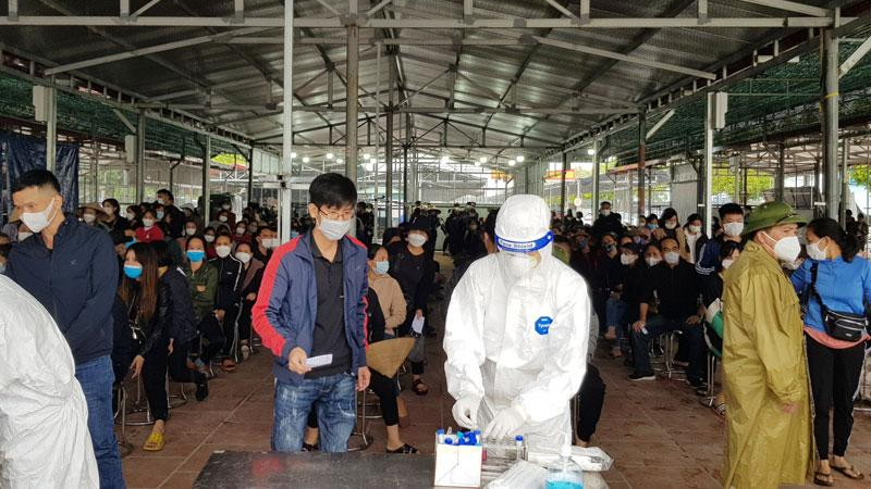 Cán bộ y tế lấy mẫu xét nghiệm cho người dân tại xã Ninh Hiệp, huyện Gia Lâm. Ảnh: Hà Nội Mới
