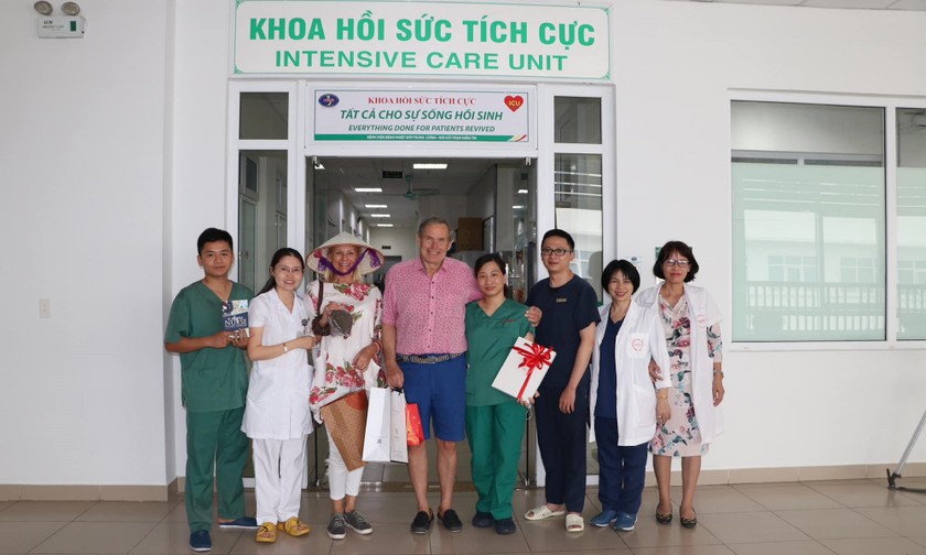 Vợ chồng người Anh, bà Shan và ông Dixong chụp ảnh lưu niệm cùng các y, bác sĩ tại Bệnh viện Bệnh Nhiệt đới Trung ương. Ảnh: BVCC