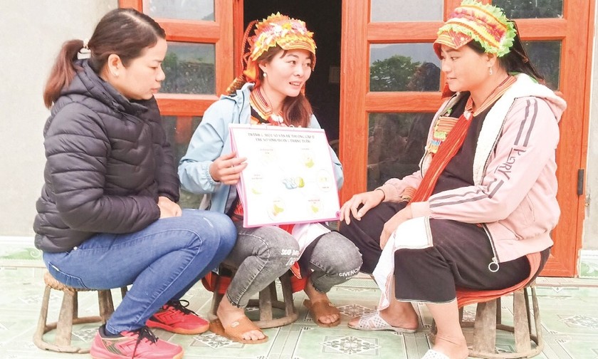 Cô đỡ Tẩn Xa Nhị (ở giữa) tuyên truyền về chăm sóc sức khỏe bà mẹ trẻ em tại Bản Lang (huyện Phong Thổ, Lai Châu). Ảnh: Báo Dân tộc và Phát triển
