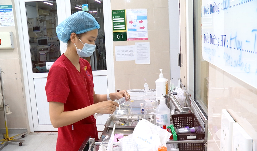 Nữ điều dưỡng Đặng Thị Hạ trong giờ làm việc tại Bệnh viện Bạch Mai. Ảnh: Hồng Hạnh