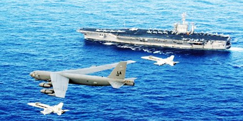 B-52 của Mỹ bay cùng chiến đấu cơ trên biển, phía dưới là một tàu sân bay trong hạm đội tàu sân bay hùng hậu của nước này.