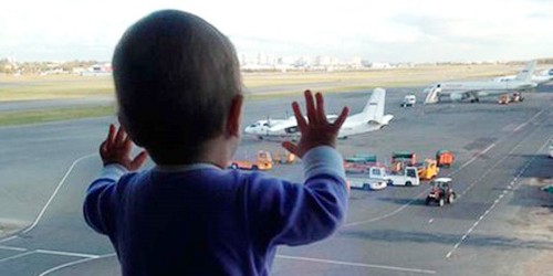 Bé Darina Gromova nhìn những chiếc máy bay qua cửa kính ở sân bay St. Peterburg