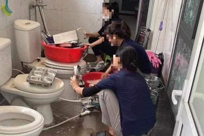 Hình ảnh các giáo viên rửa khay đựng cơm trong nhà vệ sinh. Ảnh: Mạng F.B