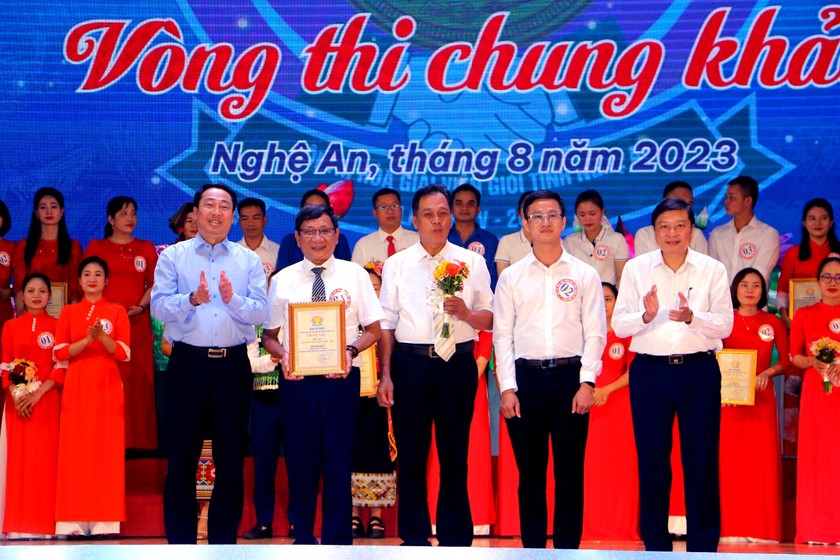Ông Lê Vệ Quốc - Cục trưởng Cục PBGDPL (ngoài cùng phía tay trái) và ông Lê Hồng Vinh - Phó chủ tịch Thường trực UBND tỉnh Nghệ An trao giải nhất cho đội thị xã Thái Hòa. Ảnh: Thiên Ý