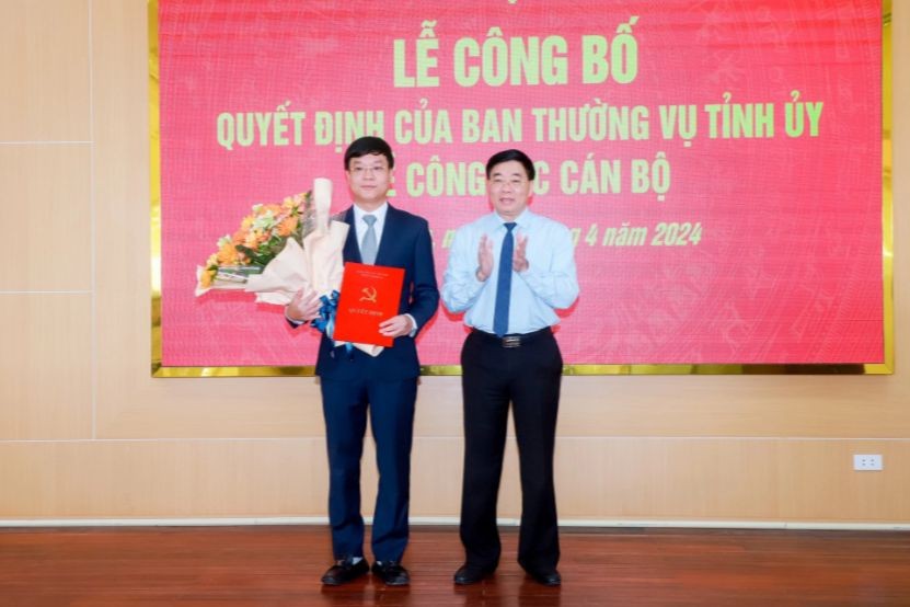 Ông Nguyễn Văn Thông - Phó Bí thư Thường trực Tỉnh ủy Nghệ An (bên phải) tặng hoa chúc mừng ông Phạm Tuấn Vinh.