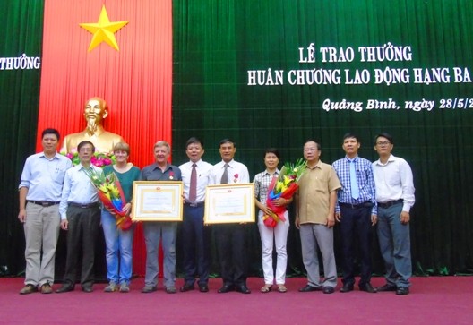 Hồ Khanh và Howard Limbert chụp ảnh lưu niệm cùng lãnh đạo tỉnh Quảng Bình và người thân tại lễ trao tặng huân chương.