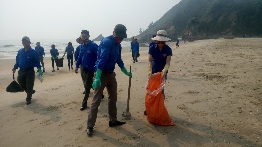 Thanh niên tình nguyện ở thị xã Ba Đồn (Quảng Bình) thu gom cá chết dọc bờ biển.