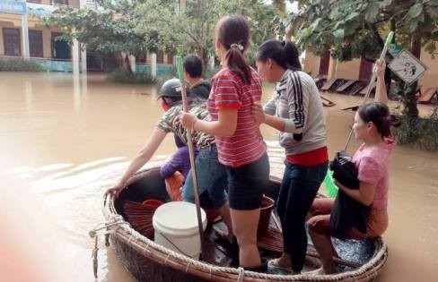 Cán bộ giáo viên Trường Tiểu học số 2 Quảng Văn, thị xã Ba Đồn chèo thuyền thúng vượt lũ vào dọn dẹp trường lớp để học sinh sớm được đến trường. Ảnh: Phương Nhạn