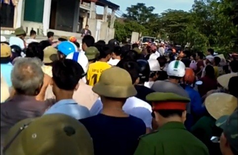 Sáng 5/7, hàng trăm người dân tập trung tại thôn 8 Tân Phong chứng kiến vụ bắt giữ 2 người khả nghi là bắt cóc trẻ em (ảnh cắt từ clip).