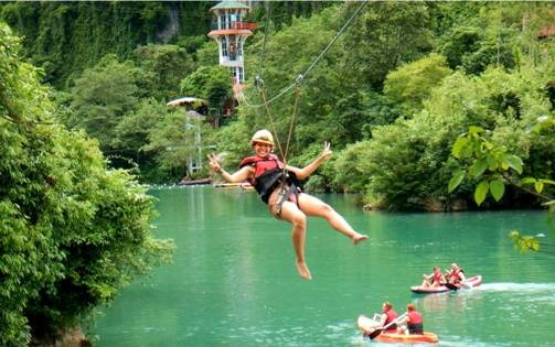 Du khách nước ngoài đắm mình trong dịch vụ đu dây Zipline ở khu vực sông Chày - hang Tối trong Vườn Phong Nha - Kẻ Bàng.