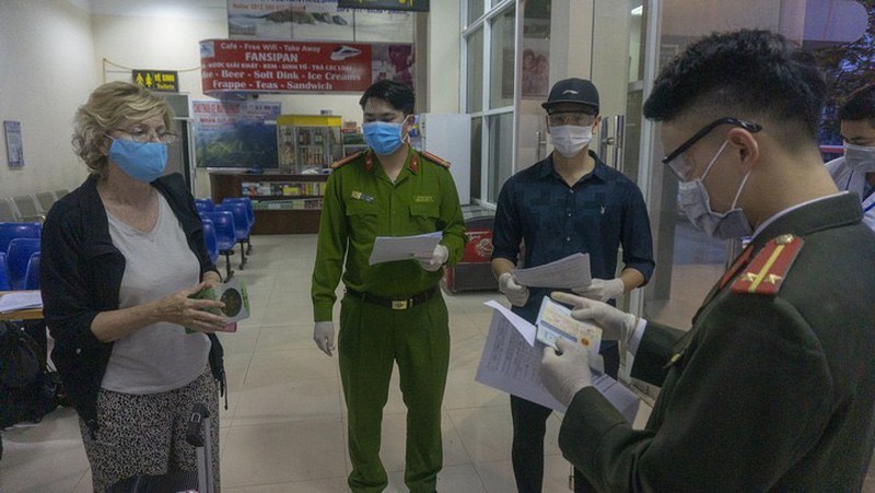 Du khách người nước ngoài phải đối chiếu tờ khai y tế với hộ chiếu khi xuống tàu ở Ga Lào Cai. Ảnh: Nguyễn Hải