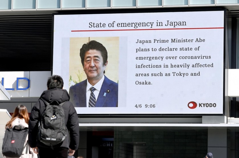 Người dân xem thông báo về việc Thủ tướng Nhật Bản Shinzo Abe dự kiến ban bố tình trạng khẩn cấp trên toàn quốc. Ảnh: KyodoTimes
