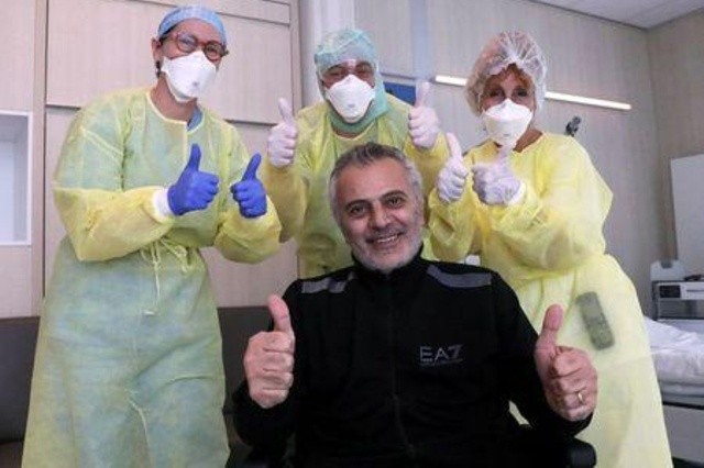 Bác sĩ người Bỉ Antoine Sassine chụp ảnh với các nhân viên y tế, cũng là đồng nghiệp đã chăm sóc ông, ngày 18/4. Ảnh: Reuters
