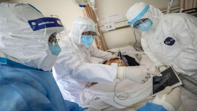 Một bác sĩ kiểm tra một bệnh nhân bị nhiễm virus corona tại một bệnh viện ở Vũ Hán (Trung Quốc). Ảnh: AFP