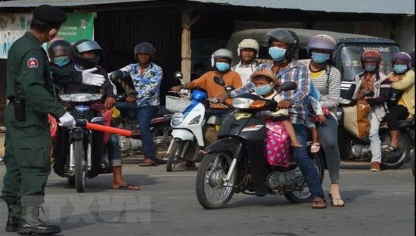 Người dân đeo khẩu trang phòng lây nhiễm COVID-19 tại Campuchia. Ảnh: AFP/TTXVN)