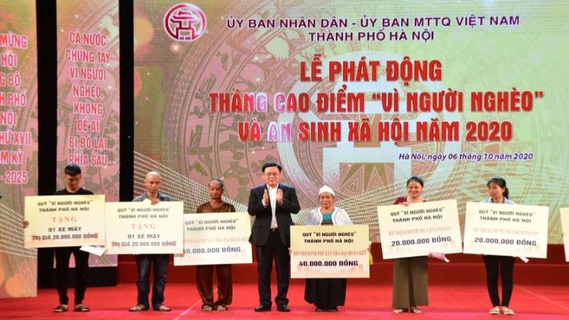 Bí thư Thành ủy Hà Nội Vương Đình Huệ trao hỗ trợ cho các hộ nghèo trên địa bàn TP Hà Nội. Ảnh: HNM