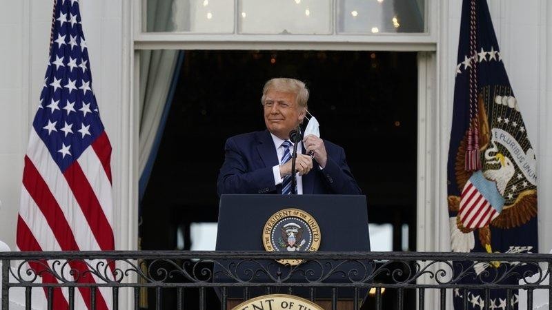Tổng thống Donald Trump tháo khẩu trang để phát biểu từ Ban công Phòng Xanh của Nhà Trắng trước đám đông những người ủng hộ hôm 10/10 tại Washington. Ảnh: AP.