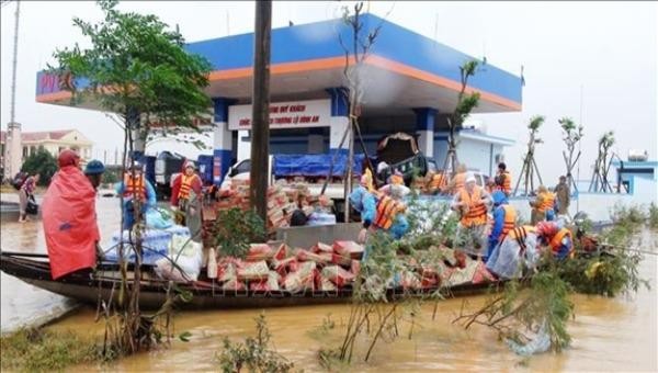 Chuyển hàng cứu trợ tới người dân ở xã Hàm Ninh, huyện Quảng Ninh, Quảng Bình. Ảnh: TTXVN.