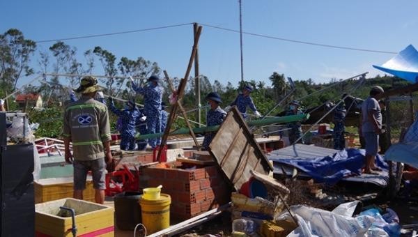Hơn 50 cán bộ, chiến sĩ Vùng Cảnh sát biển 2 hỗ trợ người dân xã Tam Quang, huyện Núi Thành (Quảng Nam) khắc phục hậu quả bão số 9. Ảnh: QĐND