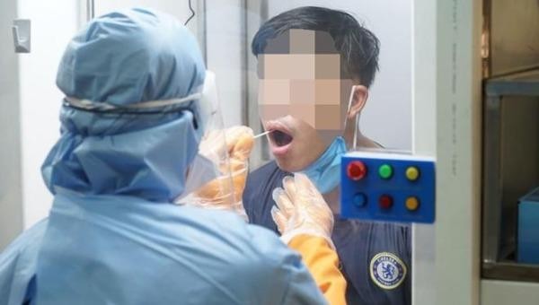 Nhân viên y tế lấy mẫu xét nghiệm người nghi nhiễm Covid-19 qua cabin tại Bệnh viện Quận 2 (TP HCM). Ảnh: Xuân Bình