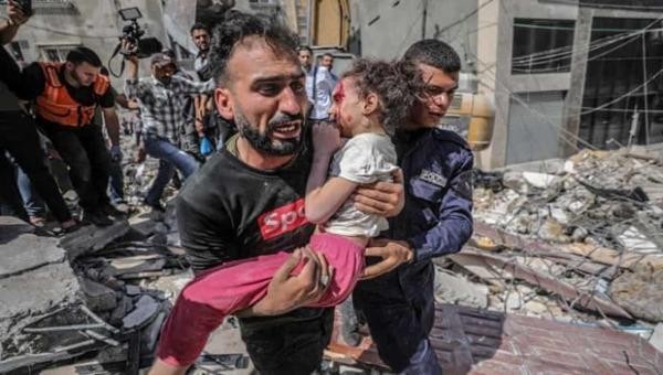 Một ông bố Palestine bế con gái khỏi đống đổ nát ở Gaza sau đợt không kích của Israel. Ảnh: EPA