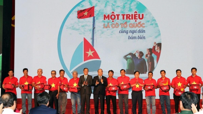 Thủ tướng Nguyễn Xuân Phúc (nay là Chủ tịch nước) tặng cờ Tổ quốc các ngư dân tiêu biểu tỉnh Kiên Giang ngày 29/7/2019. Ảnh: Quang Liêm.