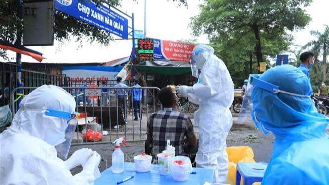 Lấy mẫu xét nghiệm SARS-CoV-2 các tiểu thương bán hàng trong chợ Xanh Văn Quán, (Hà Nội). Ảnh: TTXVN