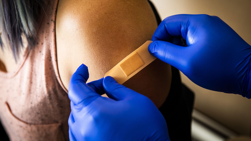 Nhân viên y tế đặt băng vết tiêm cho một bệnh nhân sau khi tiêm một liều vaccine phòng COVID-19 ở Boston (Hoa Kỳ) ngày 17/6/2021`. Ảnh: Bloomberg qua Getty Images
