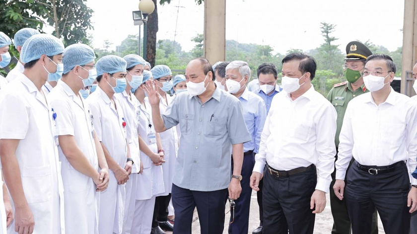 Chủ tịch nước Nguyễn Xuân Phúc tặng quà các nhân viên y tế làm việc tại cơ sở thu dung, điều trị bệnh nhân COVD-19 của Bệnh viện Đa khoa Hà Đông tại phường Hoàng Liệt, quận Hoàng Mai.