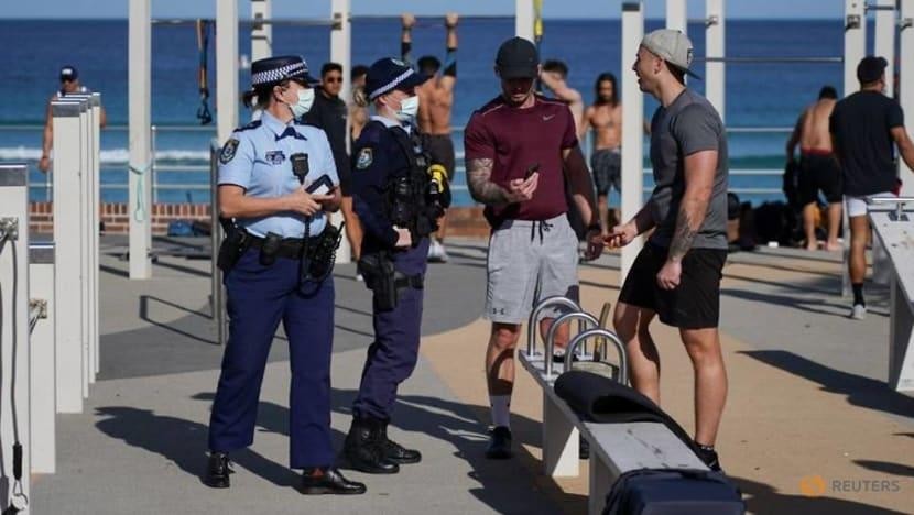 Các nhân viên cảnh sát tuần tra kiểm tra thông tin ID của những người tập thể dục ngoài trời ở khu vực bãi biển Bondi trong thời gian phong tỏa ở Sydney ngày 27/7. Ảnh: Reuters