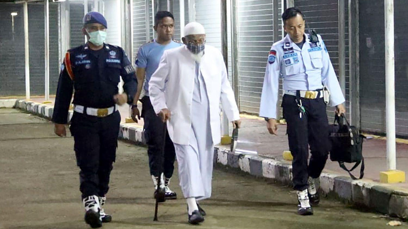Các vệ sĩ hộ tống Abu Bakar Bashir, 82 tuổi, được coi là thủ lĩnh tinh thần của nhóm khủng bố Jemaah Islamiyah, ra khỏi nhà tù Gunung Sindur ở Bogor sau khi hoàn thành bản án 15 năm vào tháng Giêng. Ảnh: Reuters