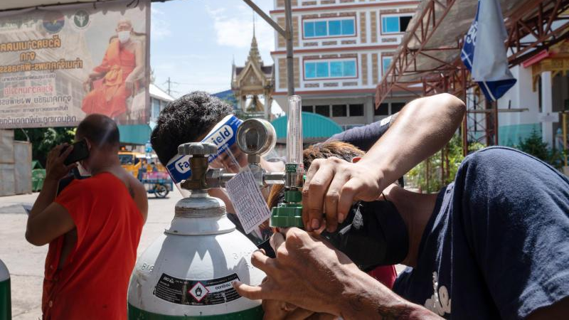 Các tình nguyện viên chuẩn bị một bình oxy cho bệnh nhân COVID-19 sau khi anh ta được xe cấp cứu đưa đến ở Wat Saphan (quận Klong Toey Bangkok) hôm 19/8/2021. Ảnh: Bloomberg