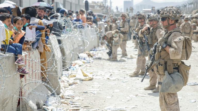 Đám đông chen chúc bên hàng rào thép gai bao quanh khu vực trong sân bay đang được quân đội Mỹ đảm bảo an ninh. Ảnh: BKP