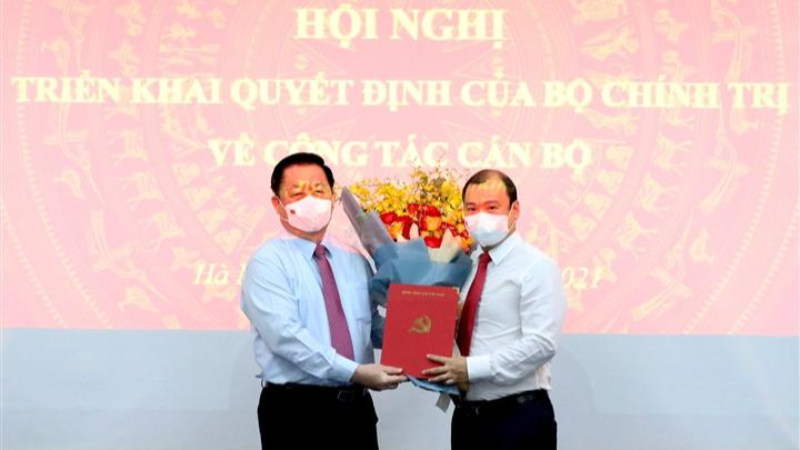 Ông Nguyễn Trọng Nghĩa, Bí thư Trung ương Đảng, Trưởng ban Tuyên giáo Trung ương trao quyết định và tặng hoa chúc mừng ông Lê Hải Bình.