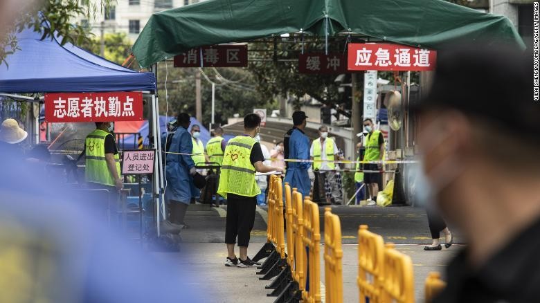 Cảnh sát, nhân viên bảo vệ và tình nguyện viên đứng tại lối vào của một khu phố bị phong tỏa ở Thượng Hải ngày 21/8, sau khi một người dân có kết quả xét nghiệm dương tính với SARS-CoV-2.
