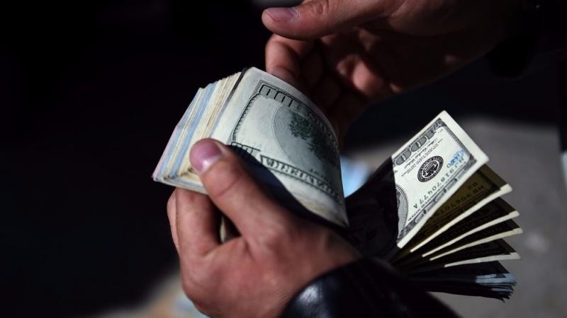 Một người đổi tiền Afghanistan đếm đô la Mỹ tại một chợ trao đổi tiền tệ ở Kabul, Afghanistan. 