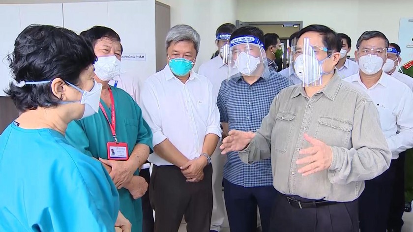 Thủ tướng Chính phủ thăm, kiểm tra và trao đổi với các y, bác sĩ Bệnh viện Dã chiến điều trị COVID-19 tỉnh tại Bệnh viện quốc tế Becamex, TP Thuận An, tỉnh Bình Dương ngày 27/8/2021. Ảnh: Báo Bình Dương