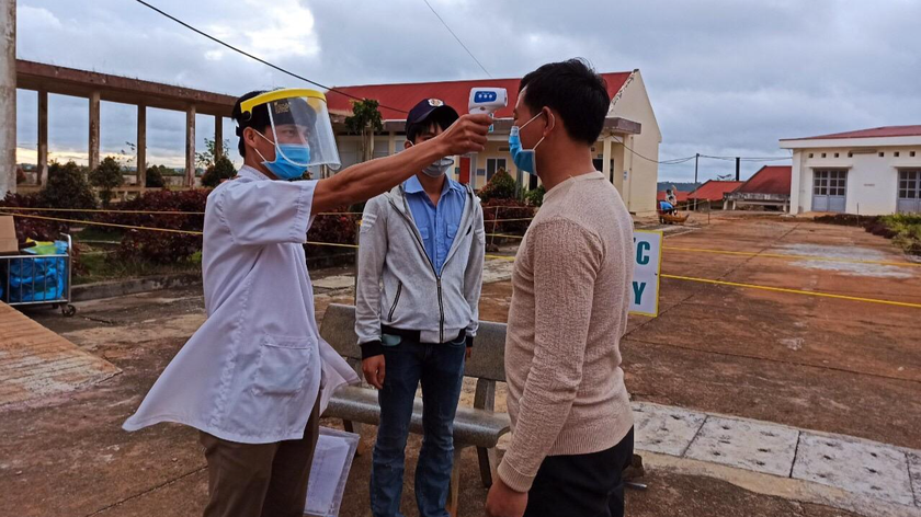 Nhân viên y tế đo thân nhiệt tại TTYT huyện Đắk Song.