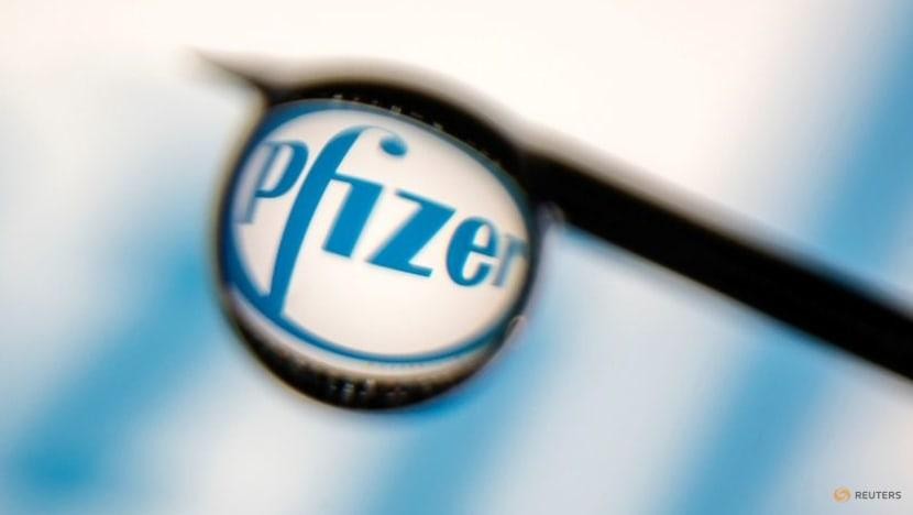 Logo Pfizer được phản ánh trong một giọt kim tiêm. Ảnh: Reuters (chụp ngày 16/3/2021)